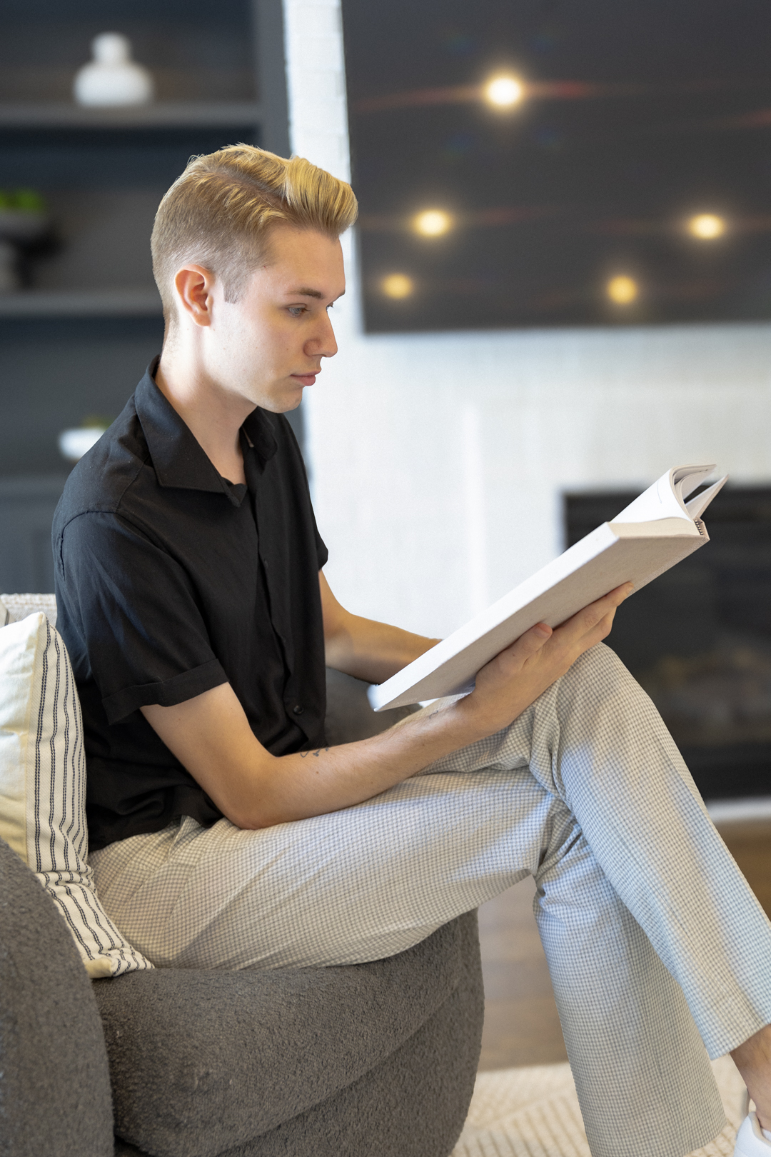 Dakota seated in profile reading a book